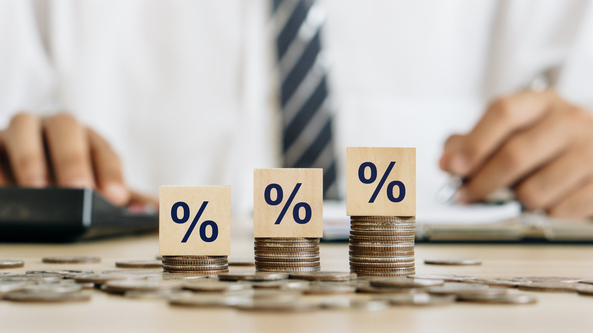 Interest rate concept.Wooden block with percentage symbol on stack of coins.