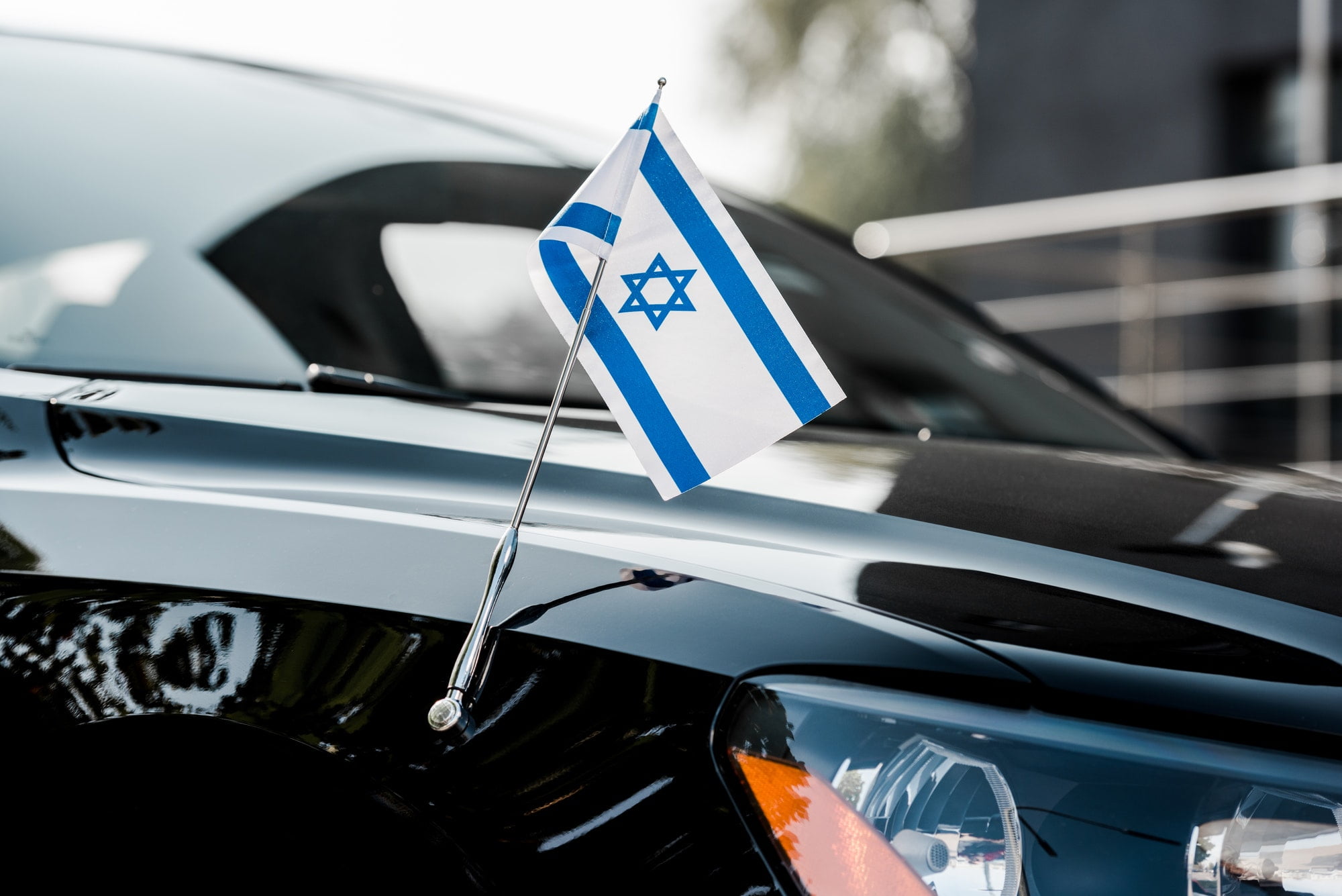 close up of israel flag on black modern car