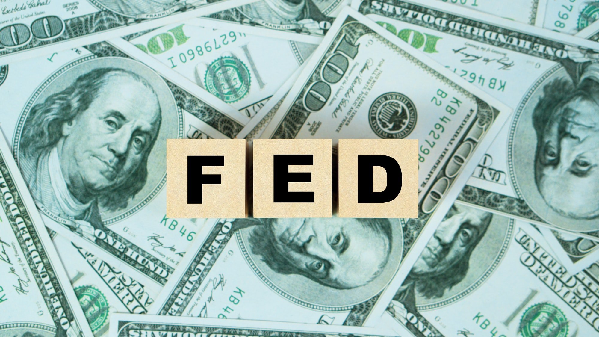FED word on Wooden block with dollar backgound.The Federal Reserve to control interest rates.