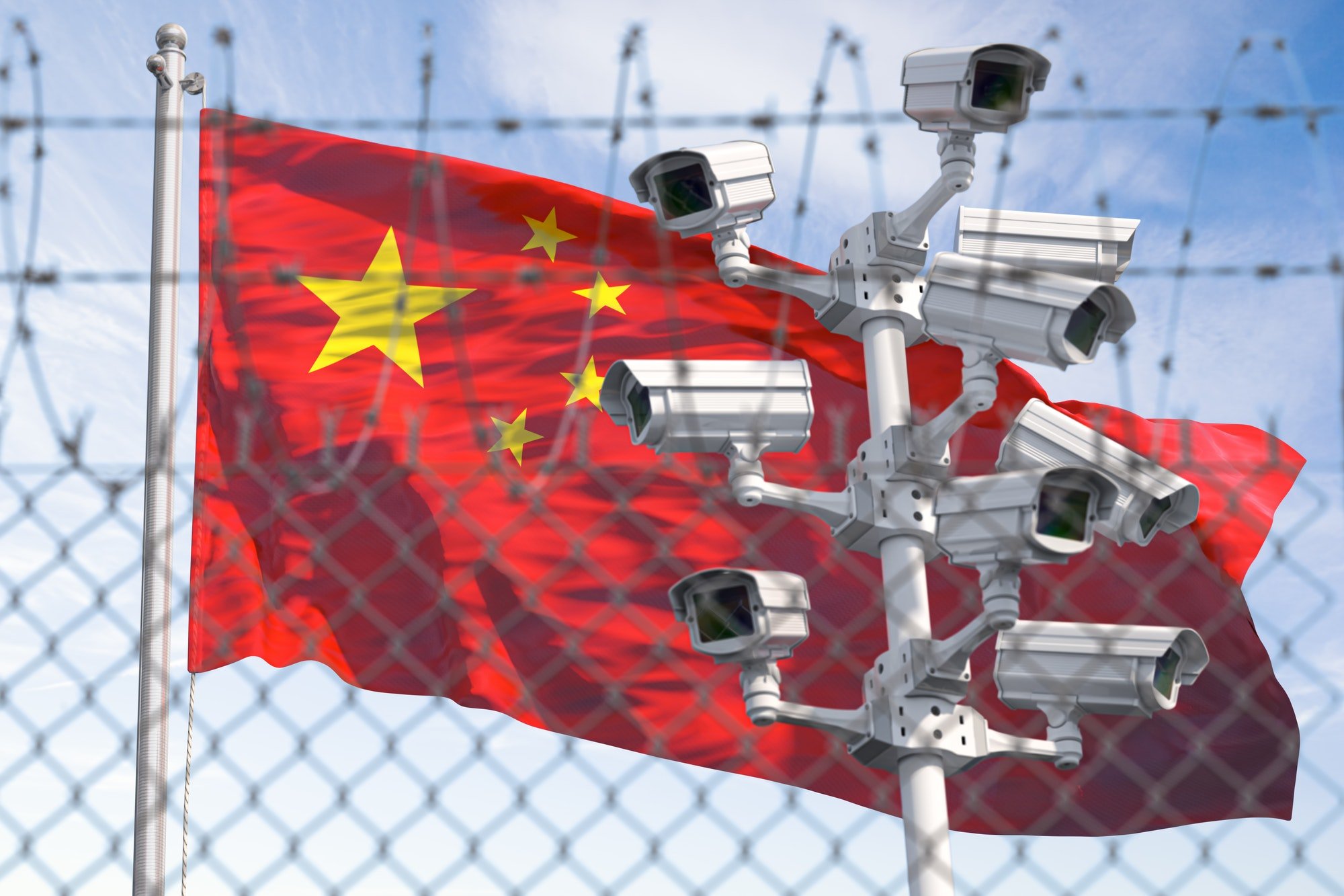 Flag of China behind barbed wire fence and cctv cameras.